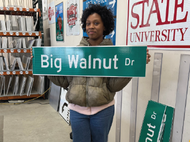 student holding a road sign